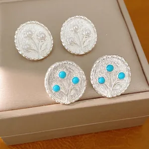 Elegante ronde zilveren bloem oorknopjes met parels en turquoise gekleurde harskralen