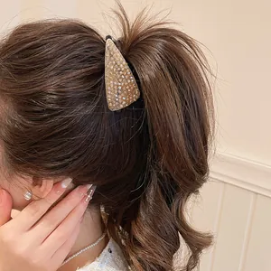 Detail van een sprankelende kristallen haarklem gedragen in een elegante paardenstaart.