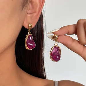 Detail of vintage irregular purple resin drop earrings with gold-plated metal base