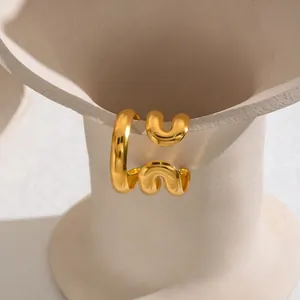 Nahaufnahme eines minimalistischen, 18 Karat vergoldeten Edelstahlrings mit Wellenform