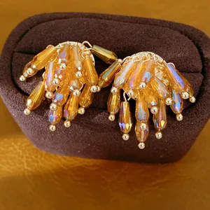 Exquisite close-up of amber glass tassel earrings featuring delicate golden bead details