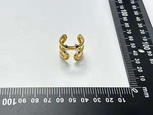 Detailansicht eines vergoldeten, gedrehten Rings, der mit einem Lineal gemessen wird
