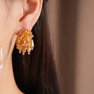 Elegant amber glass fringe stud earrings worn on ear showing faceted crystal detail