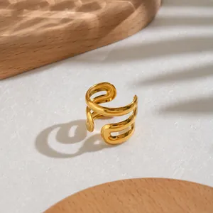 Nahaufnahme eines minimalistischen vergoldeten Edelstahlrings mit offenem Wellendesign.