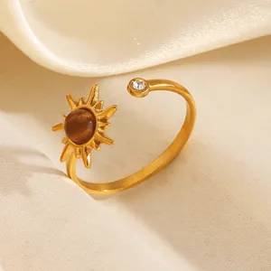Anillo abierto de sol en acero inoxidable dorado con piedra marrón y detalle de cristal