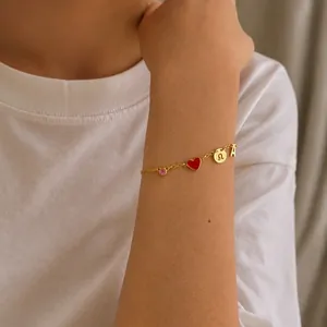 Gouden bedelarmband met rood hartje, roze zirkoon en bedel hanger met de letter A.