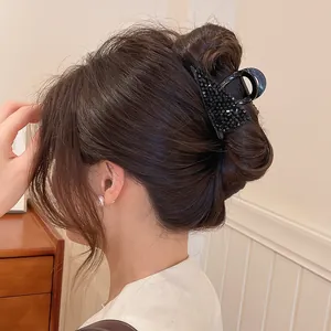 Detailweergave van een zwarte kristallen haarklem die een stijlvolle knot vasthoudt