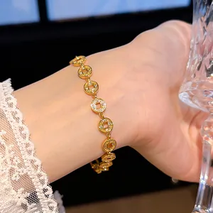 Elegantes, 24k vergoldetes Armband mit zirkonbesetzten Münzanhängern am Handgelenk Detail