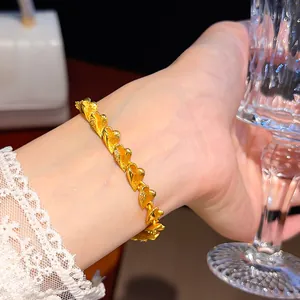 Nahaufnahme eines eleganten vergoldeten Herzarmbands mit Zirkonsteinen am Handgelenk
