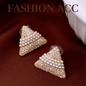 Gros plan de boucles d'oreilles triangulaires dorées 18k avec perles et zircons