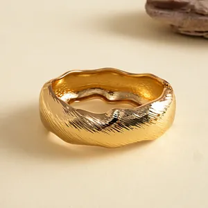 Detailansicht eines vintage goldenen, gewellten und strukturierten Armreifs.