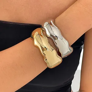 Detaillierte Ansicht von wellenförmigen goldenen und silbernen Armreifen an einem Modellarm