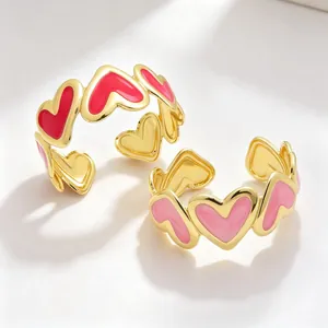 Primer plano detallado de brazaletes de esmalte de corazón chapados en oro de 18k