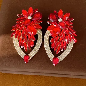 Détail macro de boucles d'oreilles fleur en cristal rouge avec accents de gouttes