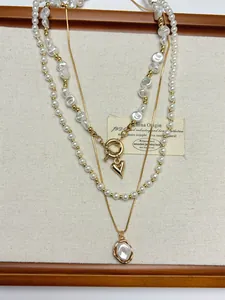 Gros plan d'un collier vintage à plusieurs rangs avec perles baroques et cœur
