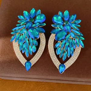 Détail de boucles d'oreilles fleur en cristal bleu avec bordure en strass brillant