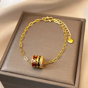 Retro 24K gold plated bracelet with red enamel and zircon barrel charm on jewelry box
