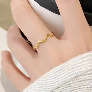 Gros plan d'une bague vague minimaliste en acier titane plaqué or 18 carats pour femme