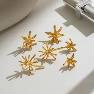 Detailed macro view of 18K gold plated stainless steel stud earrings in fireworks shapes.