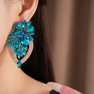 Grandes boucles d'oreilles fleurs avec cristaux bleus et verts sur un mannequin