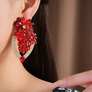 Détail d'une boucle d'oreille fleur en strass rouge avec cadre serti de cristaux.
