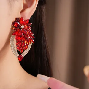 Gros plan de boucles d'oreilles fleur en cristal rouge avec détails en strass