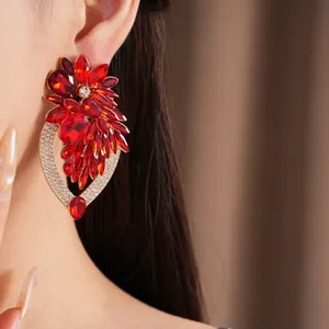 Vue détaillée de grandes boucles d'oreilles fleurs en cristal rouge sur l'oreille du mannequin
