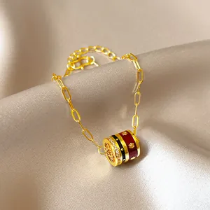 Close-up of 24K gold plated chain bracelet with red enamel and zircon stones detail