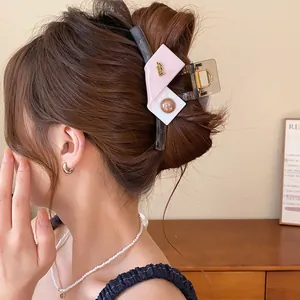 Macro view of geometric color-block hair claw clip in an elegant bun hairstyle