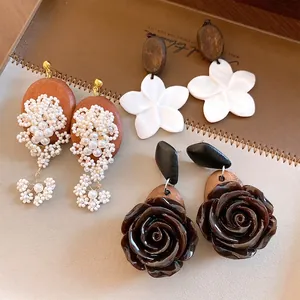 Handgemaakte vintage houten en schelpbloem oorknopjes met elegante parelclusters