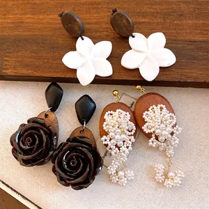 Vintage assortiment houten oorbellen met schelpbloemen en parels voor een elegante look.