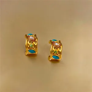 Detailed macro view of vintage gold hoop earrings with pearls and colorful stones