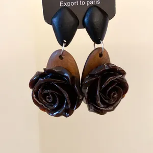 Macro-weergave van vintage houten en donkerbruine rozenbloem oorbellen voor dames