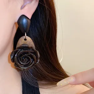 Vintage donkerroze oorbellen met houten schelprug en zilveren naald