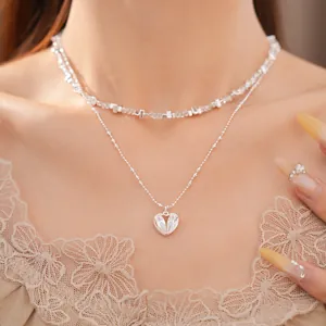 Primer plano de collar de doble capa con cuentas de vidrio y corazón de circón.