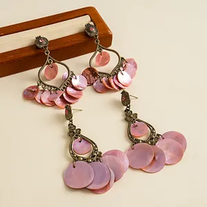 Detailansicht von Vintage-Bronze-Ohrringen mit Quasten aus rosa Muschelscheiben.