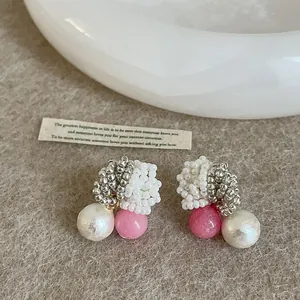 Close-up detail of Korean style beaded pearl earrings with pink stone accent