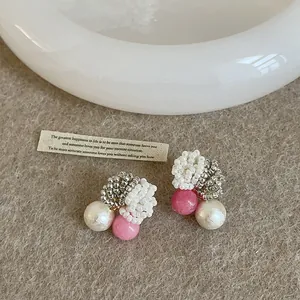 Detailed view of handmade beaded earrings with pink and white pearls