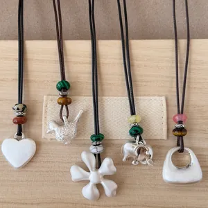Vue détaillée de divers pendentifs argentés brossés avec des perles de pierre sur des cordons