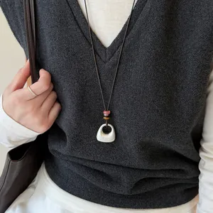 Vue détaillée d'un collier coréen avec pendentif en argent brossé et perles colorées.