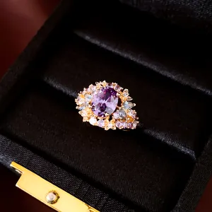 Gedetailleerd overzicht van luxe 18k goud vergulde ovale ring met paarse stenen in doos.
