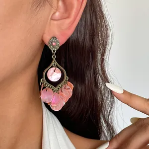 Detaillierte Makroansicht von Vintage-Ohrringen mit rosa Muschelscheiben und Strass