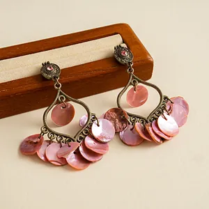 Detailansicht von Vintage-Ohrringen mit rosa Muschelscheiben und rosa Strasssteinen.