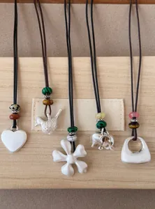 Vue détaillée des colliers en argent brossé avec perles en formes de cœur et d'éléphant