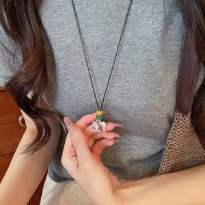 Primer plano de un collar con colgante de elefante plateado con cuentas de colores y cordón