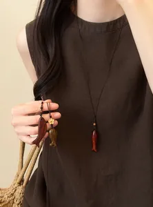Vue détaillée des pendentifs de poisson en bois faits main sur un collier ethnique rétro
