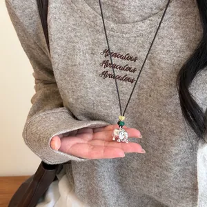 Détail du collier pendentif éléphant en argent avec perles vertes et jaunes