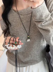 Gros plan de colliers en argent de style coréen avec divers pendentifs et perles