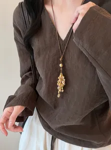 Detailansicht einer Bohème-Halskette mit Lederschnur und Muschelquaste an einem Modell