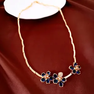 Elegant 18k gold plated zircon flower necklace displayed on a brown satin luxury fabric.